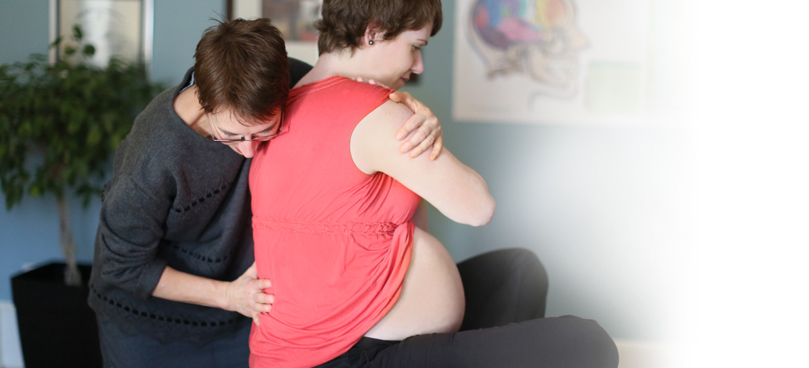 Chiro et femmes enceintes. Isabelle Gendron, chiropatricienne donnant un soin chiropratique à une femme enceinte.